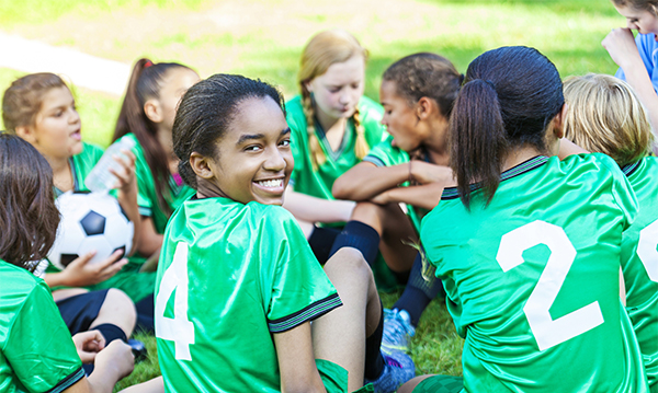 Beautiful African American girl smiling with her soccer team